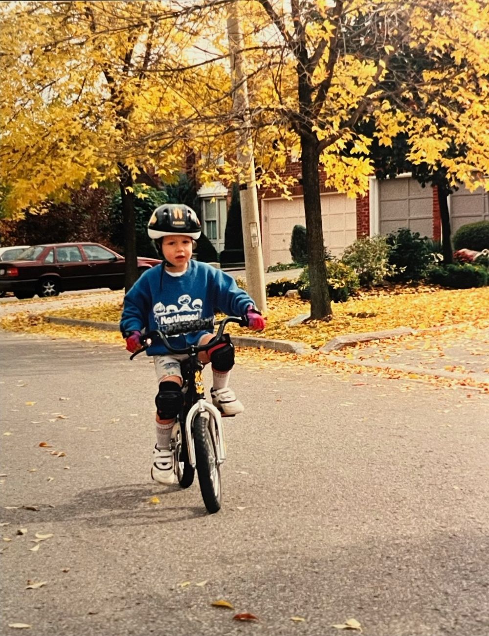Michael as a kid riding down an autumn street